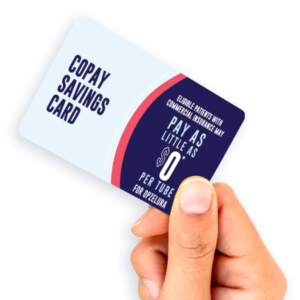 A hand holds a Copay Savings Card that states eligible patients with commercial insurance may pay as little as $0 per tube for Opzelura.