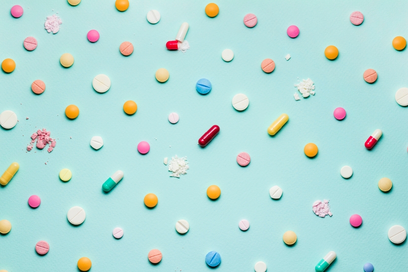 Colorful pills and capsules combating antibiotic resistance on a blue background.