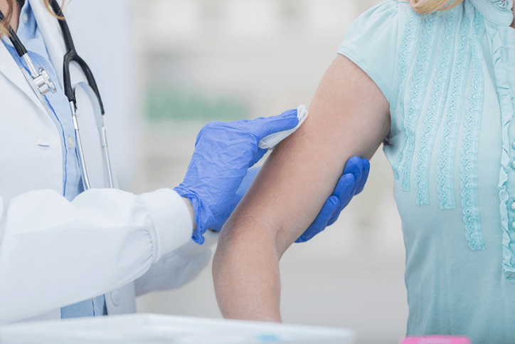 A woman is receiving a flu vaccine from a doctor.