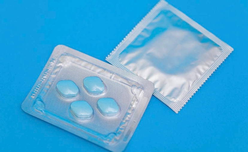 Two packets of condoms on a blue background, highlighting the importance of safe sexual practices.