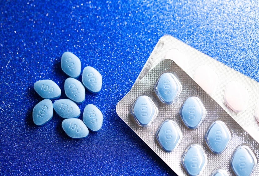 A pack of viagra pills on a blue surface.