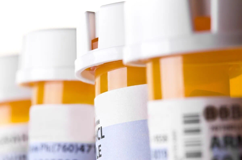 A row of prescription bottles on a white background, showcasing Sunovion's prescription drug savings.