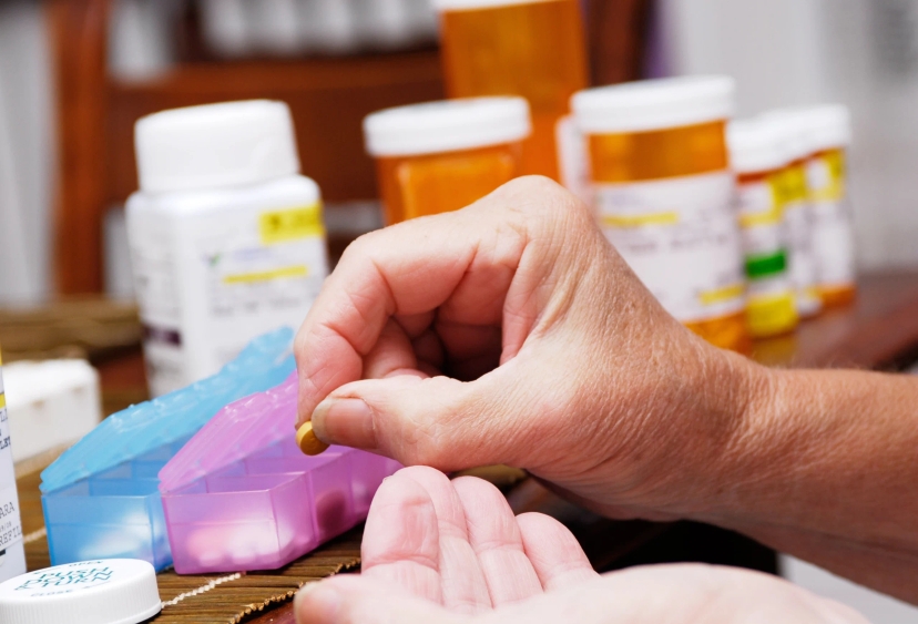 A person is carefully packaging Amneal prescription drugs into a box, ensuring maximum prescription drug savings for customers.