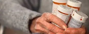 A woman is holding a bottle of Teva Cares pills, benefiting from prescription drug savings.