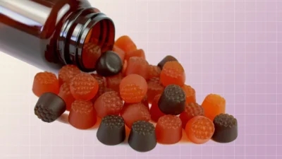 A colorful assortment of vitamin gummies on a purple background.