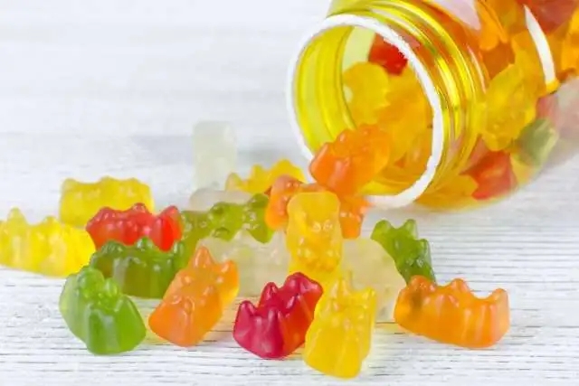 A jar of vitamin gummies on a wooden table.