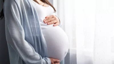 A pregnant woman holding her belly, illustrating the joy and anticipation of planning pregnancy.