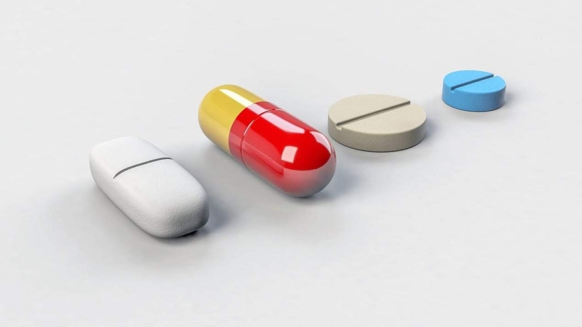 Various pharmaceutical pills and a capsule containing Amycretin on a white background.