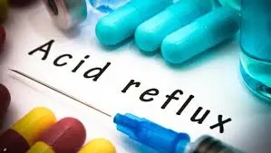 Close-up image showing the words "Acid reflux" surrounded by medical pills and a syringe, highlighting possible treatments and remedies.