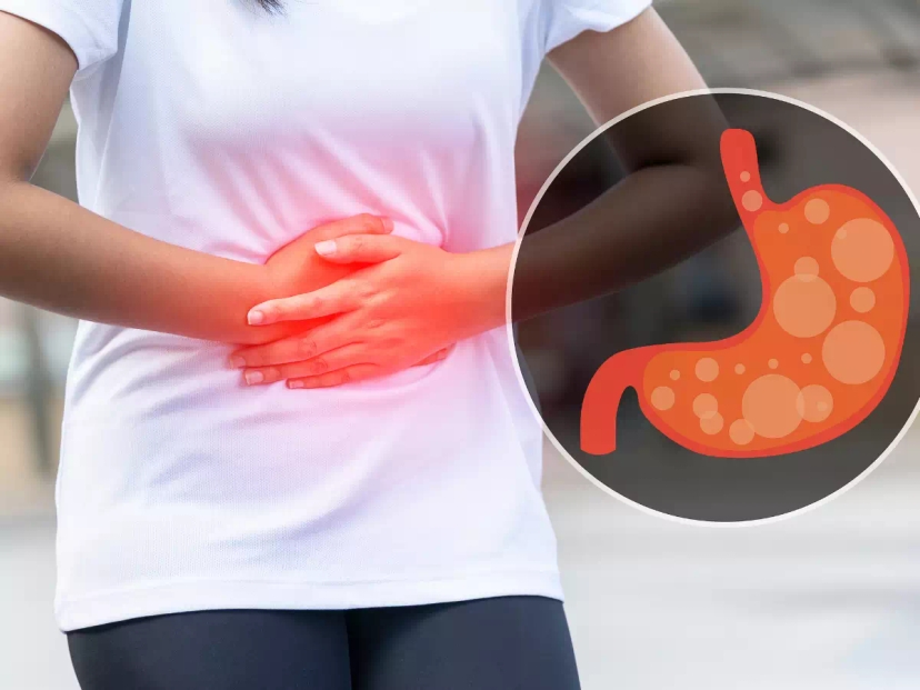 a person holding their stomach due to gas issues which can be linked to colorectal cancer