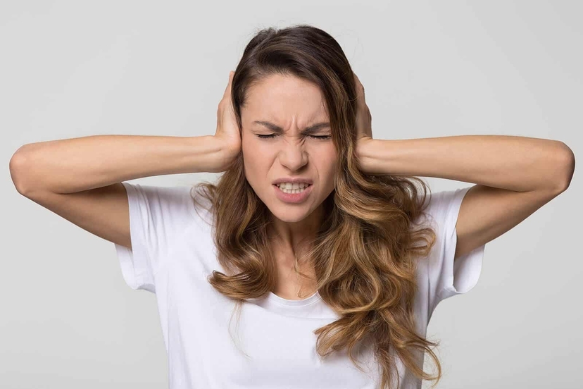 An image of a lady suffering with symptoms of Tinnitus
