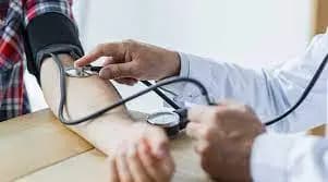 A doctor performing an NHS Health check by measuring a patient's blood pressure.