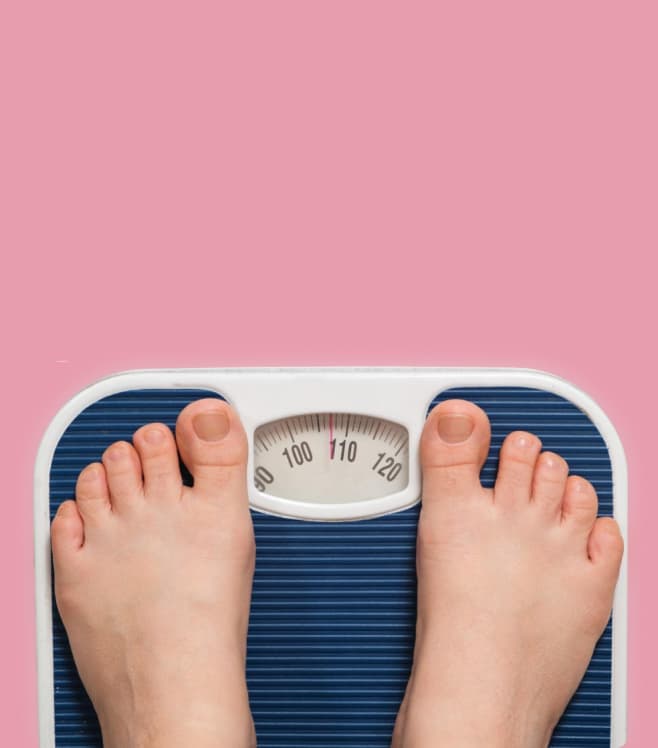 An image of large feet on a weighing scale on a pink background, representing the BMI risk feature