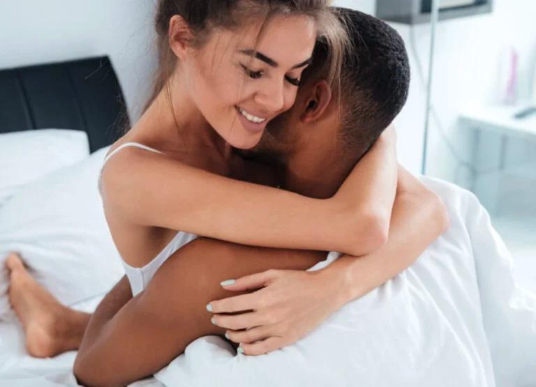 A couple embracing in bed.