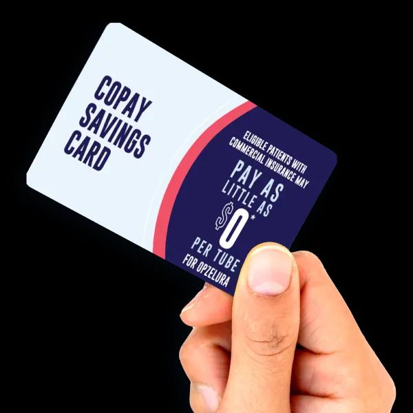 A hand holds a Copay Savings Card that states eligible patients with commercial insurance may pay as little as $0 per tube for Opzelura.