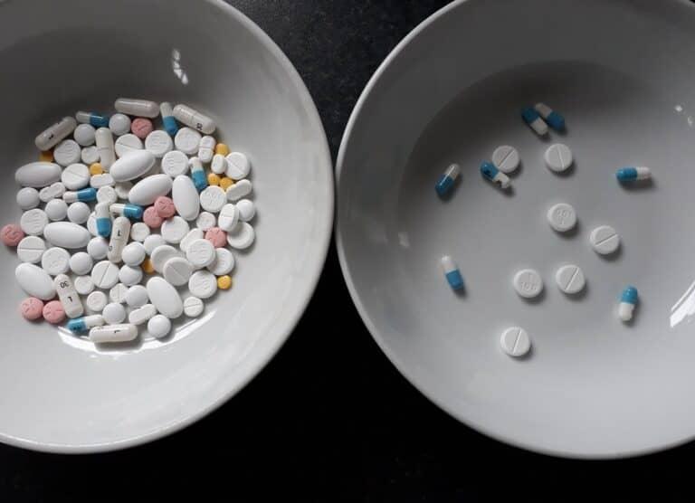 Two white bowls are displayed; the left bowl is filled with a variety of pills and tablets in different colors and shapes, while the right bowl, indicative of deprescribing efforts, contains a smaller assortment of white pills and blue-white capsules.