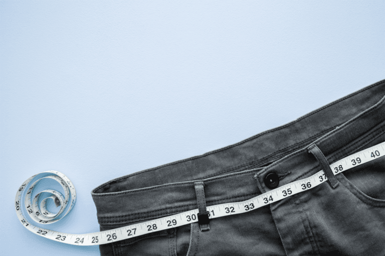 A pair of jeans with a BMI measuring tape on them.