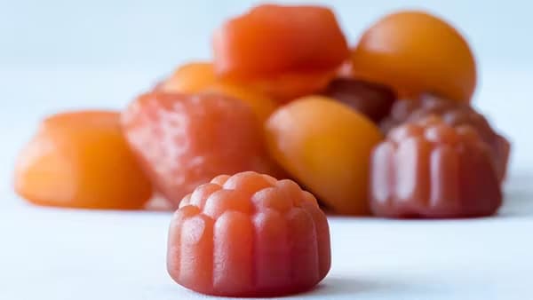 A pile of gummy vitamins on a white surface.