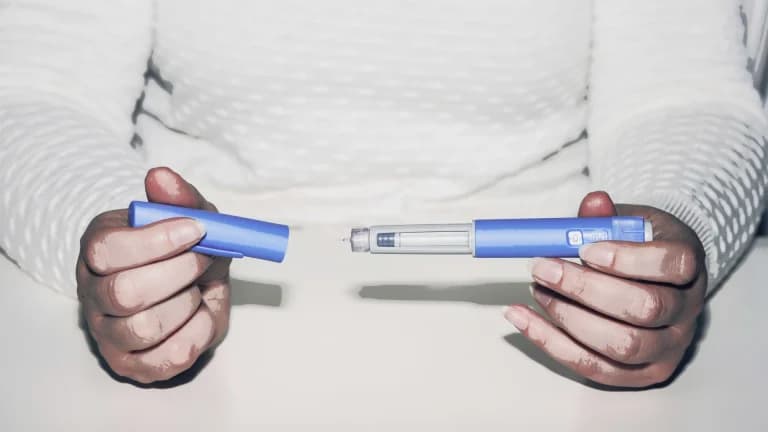 a person holding a ozmepic pen which can be used for wegiht loss and checking if it is the same as retatrutide