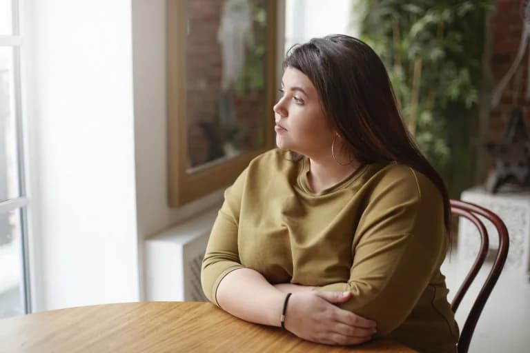 a person sat down thinking about the symptoms of anorexia nervosa