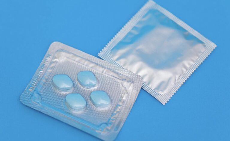 Two packets of condoms on a blue background, highlighting the importance of safe sexual practices.