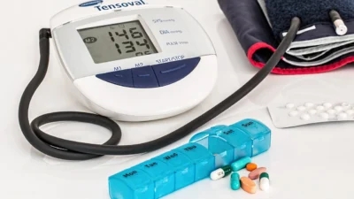 A blood pressure monitor accompanied by medications for managing blood pressure.