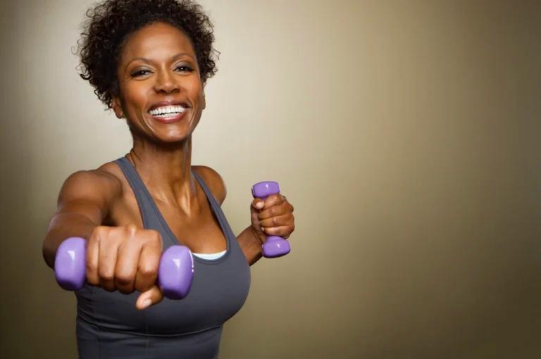 A woman showcasing the 7 best workouts with purple dumbbells for weight loss in a photo.