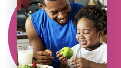 A man and a child eating together at the kitchen table in England's Healthiest Cities.