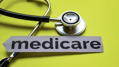 A stethoscope and medicare sign on a yellow background showcasing Medicare Advantage.