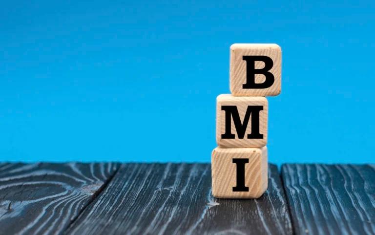 A wooden block with the word bmi stacked on top of it showcases the consequences of an imbalanced BMI.