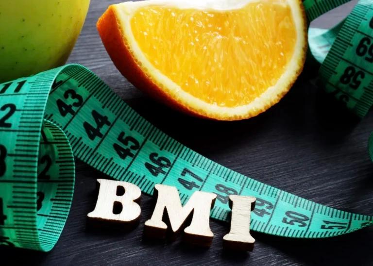 A measuring tape with the word BMI next to an apple.