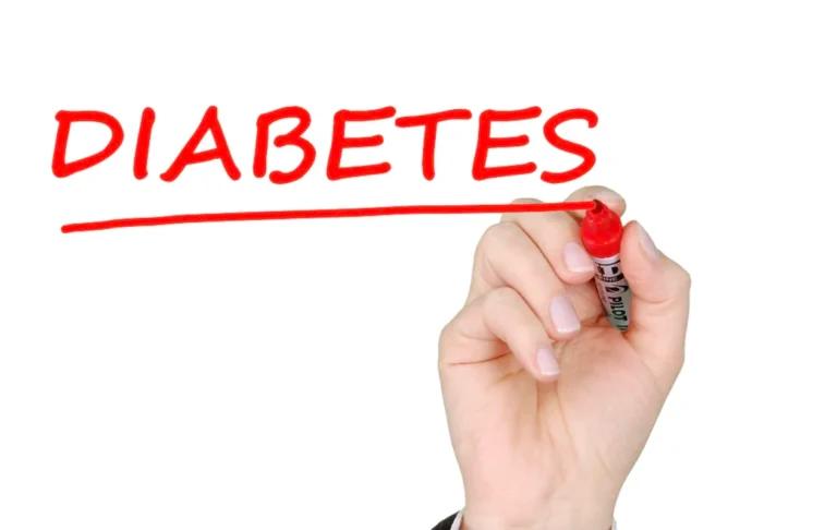 A person diagnosed with Type 2 Diabetes writing the word diabetes with a marker.