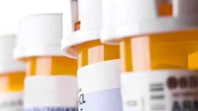 A row of prescription bottles on a white background, showcasing Sunovion's prescription drug savings.