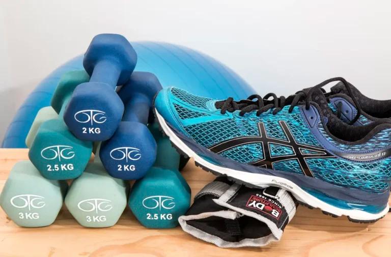 A pair of asics running shoes for physical activity and a pair of dumbbells for exercise.