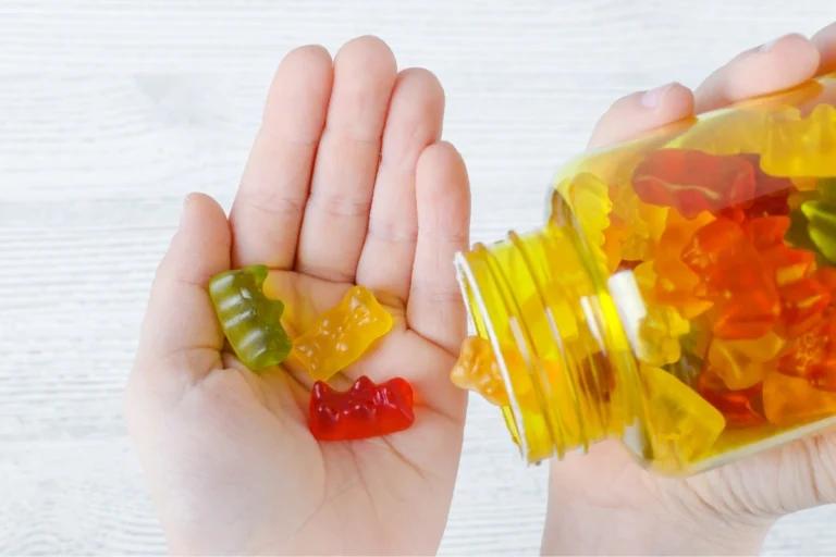 A person's hand holding a jar of gummy bears, possibly for work purposes.