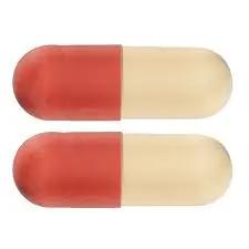 Two red and beige capsules, possibly containing pregabalin, placed horizontally with the red halves on the left. Take with caution, as they may interact with other painkillers.