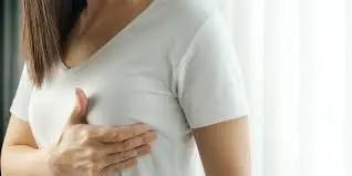 Woman touching the area under her breast, checking for under-breast rash